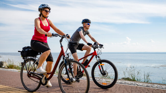 Healthy lifestyle - people riding bicycles at seaside Credit. getty