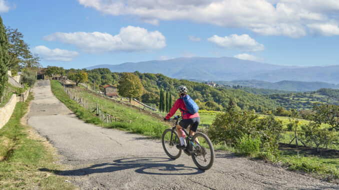 nice senior woman riding her electric mountain bike in Tuscany, Italy